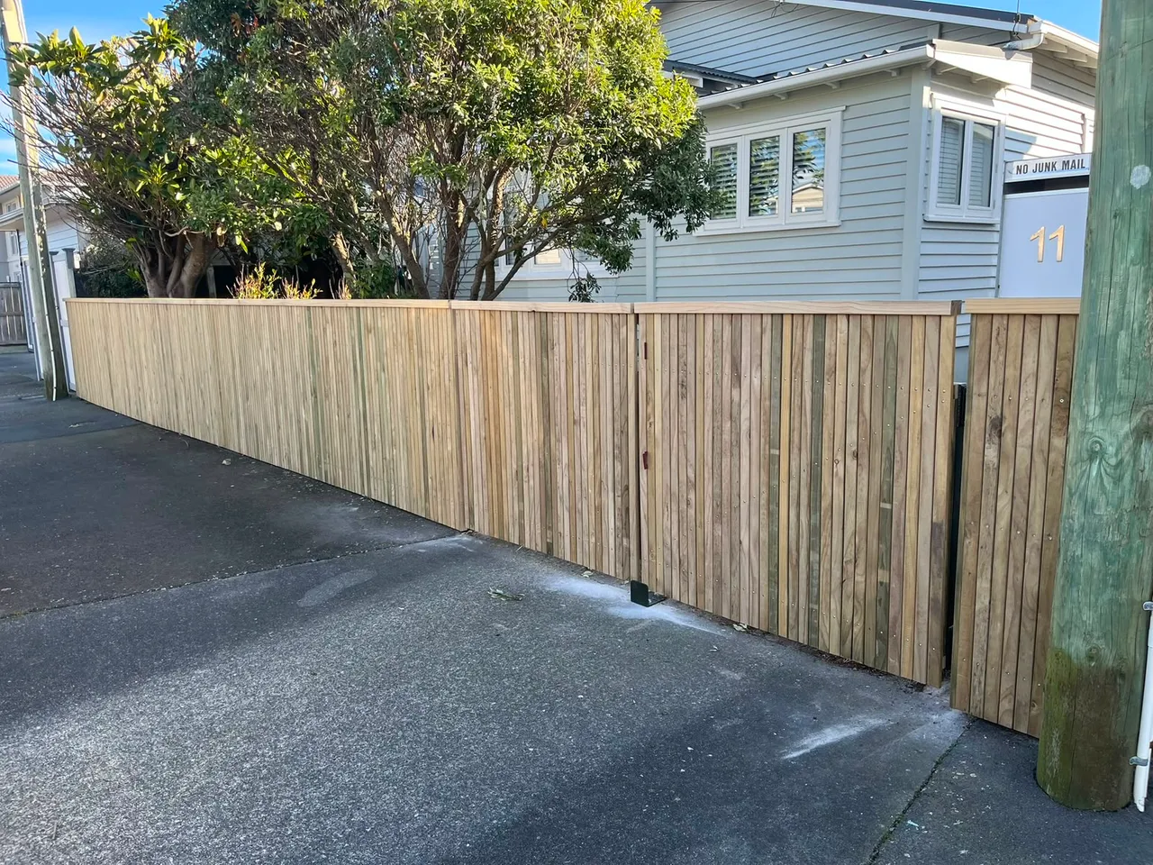 Horizontal timber slat fence along a Wellington driveway