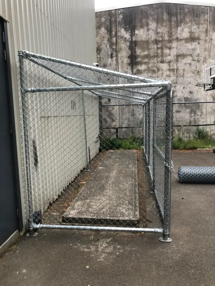 Galvanised chain-link enclosure against a Wellington building